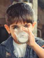 photo of boy drinking glass of milk