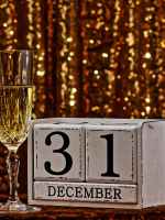 two glasses of white wine next to a block calendar