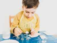 crop boy with dry solution and glasses preparing for experiment