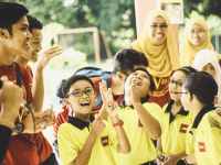 laughing children in between woman and man at daytime