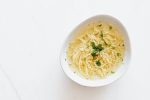 bowl with chicken noodle soup and parsley