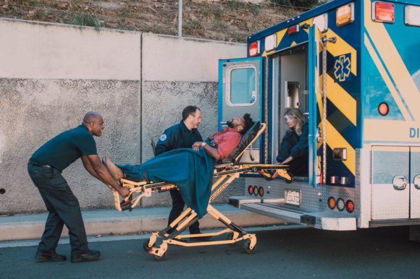 paramedics helping a man on a stretcher