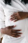 crop pregnant black woman touching belly