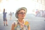 depth of field photography of woman in pastel color sleeveless shirt and white sunhat