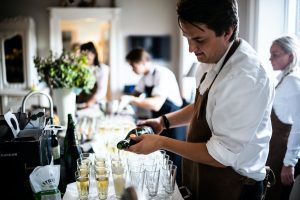 man pouring wine on glasses
