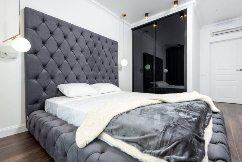 photograph of a bedroom with a gray comforter