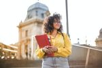 woman in yellow jacket holding books